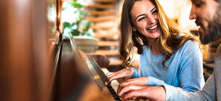 Woman and man playing the piano together